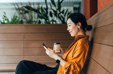 Claire, a business owner, smiles at customers while holding a tablet