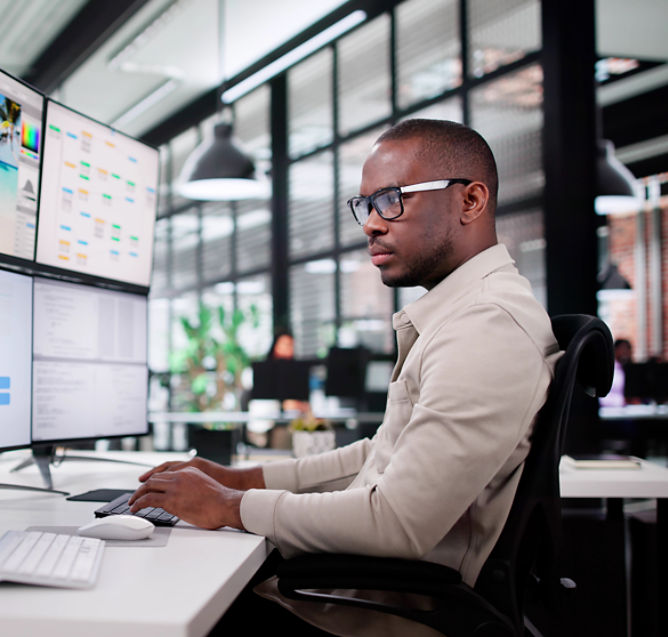 Guy working on four monitors