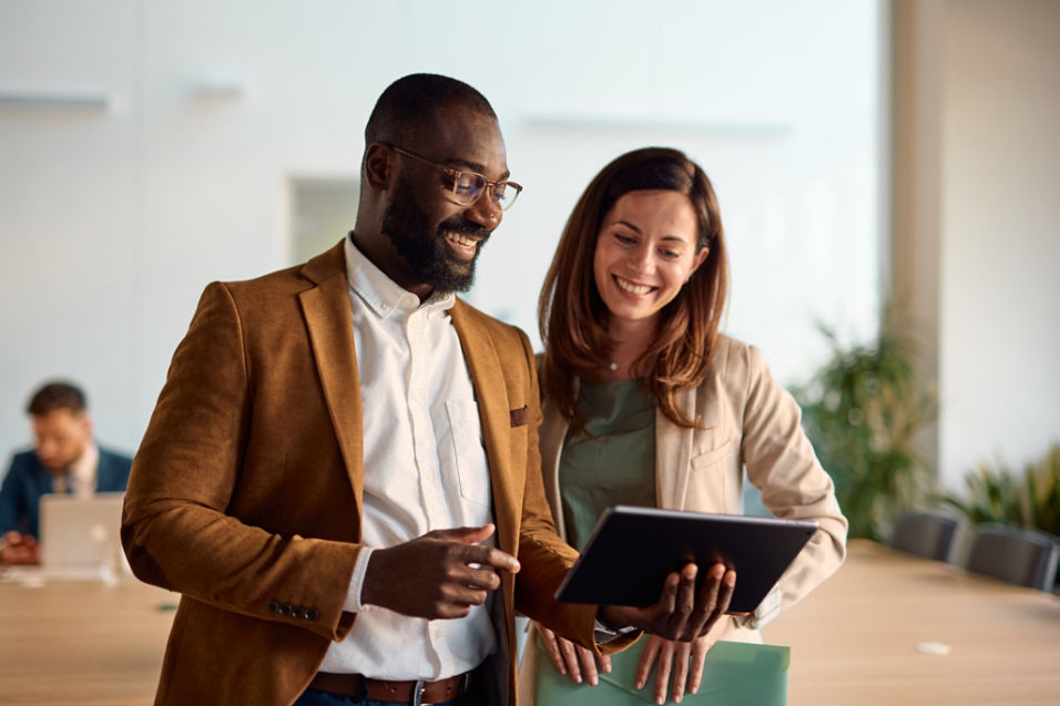 Claire, a business owner, smiles at customers while holding a tablet