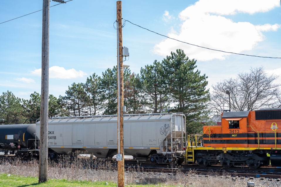 Train on tracks with electric poles in view. Sensors are housed on electric poles