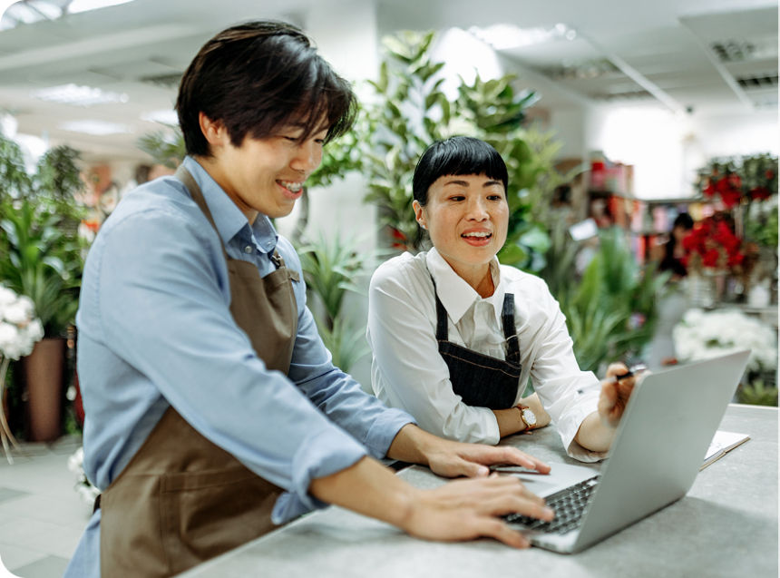 Claire, a business owner, smiles at customers while holding a tablet