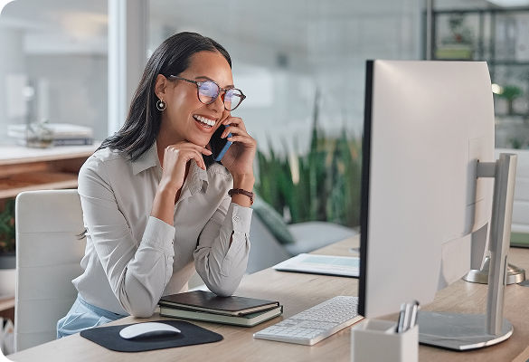 Woman on the phone looking at computer monitor