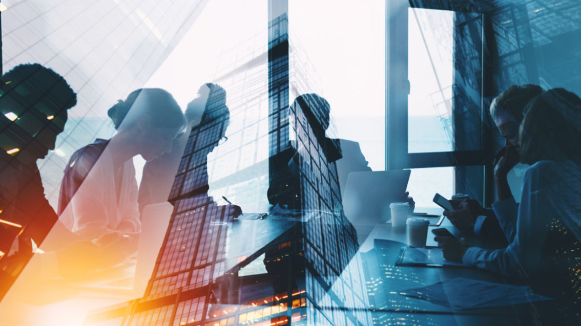 city reflected in window of a conference room