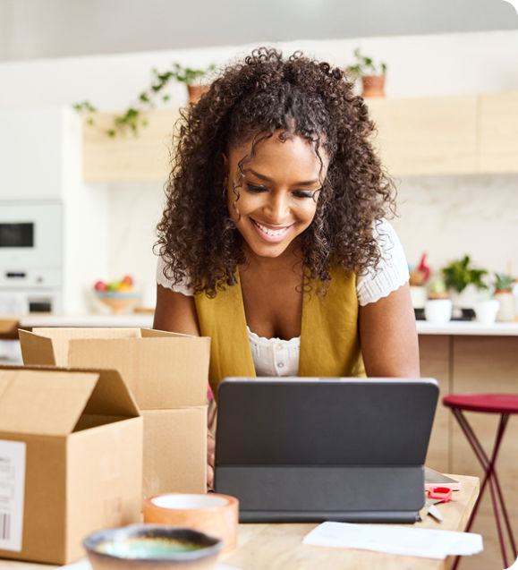 Woman looking at tablet with shipping boxes on the table