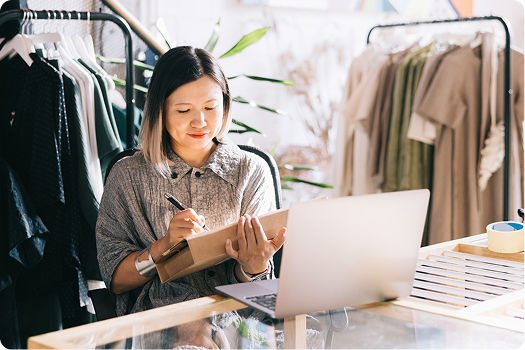 Woman in a clothing store working on a laptop