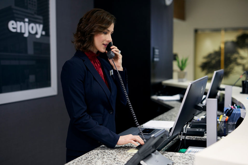 Woman on the phone at hotel desk